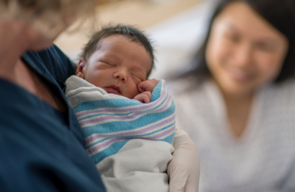 Newborn baby wrapped in a blanket, being held | BCBS of Tennessee