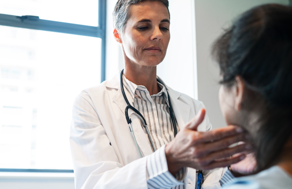 Doctor in white coat checking patient's jaw | BCBS of Tennessee