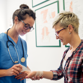 Medical staff member applies bandage to their patient's wrist