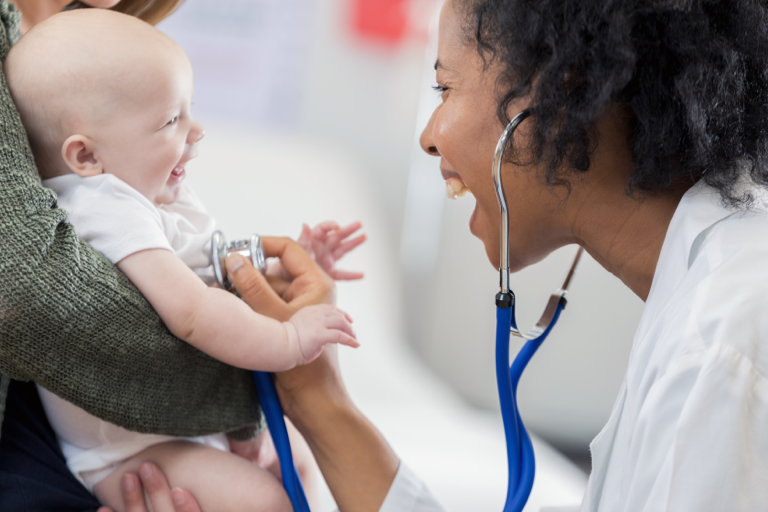 Doctor in white coat laughing with baby | BCBS of Tennessee