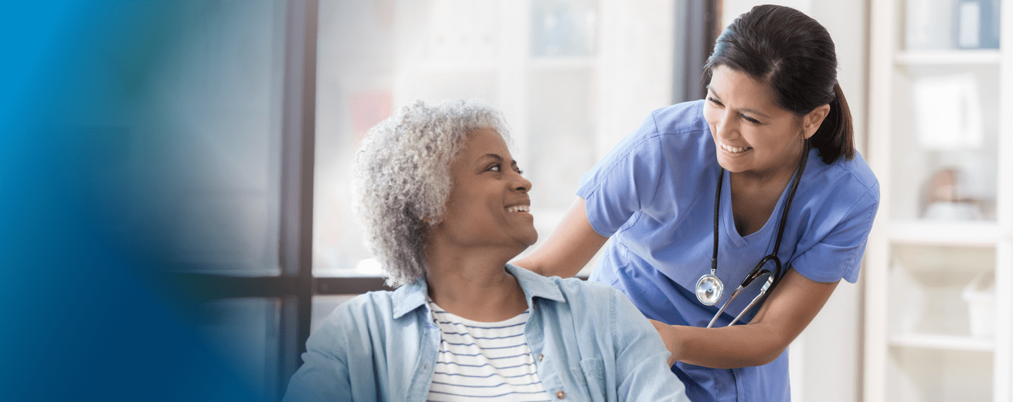 Female medical staff assisting a woman in a wheelchair
