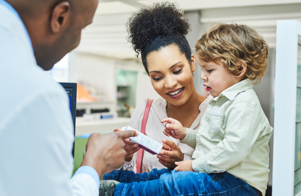 Child sitting on counter while mom talk to pharmacist | BCBS of Tennessee