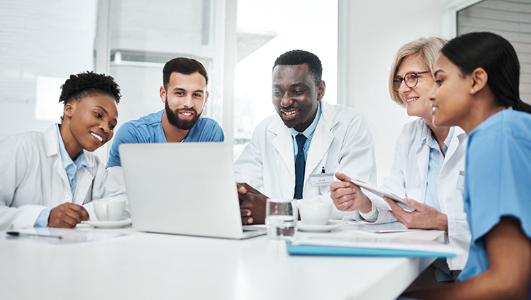 A group of providers sitting at a table looking at a presentation