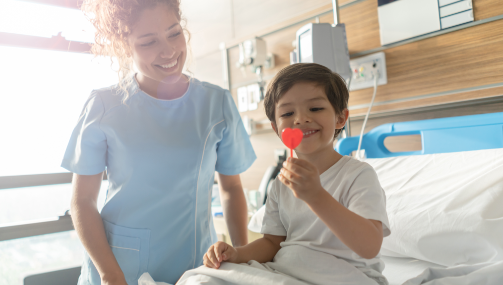 Female medical staff smiling at child patient with candy in his hand | BCBS of Tennessee