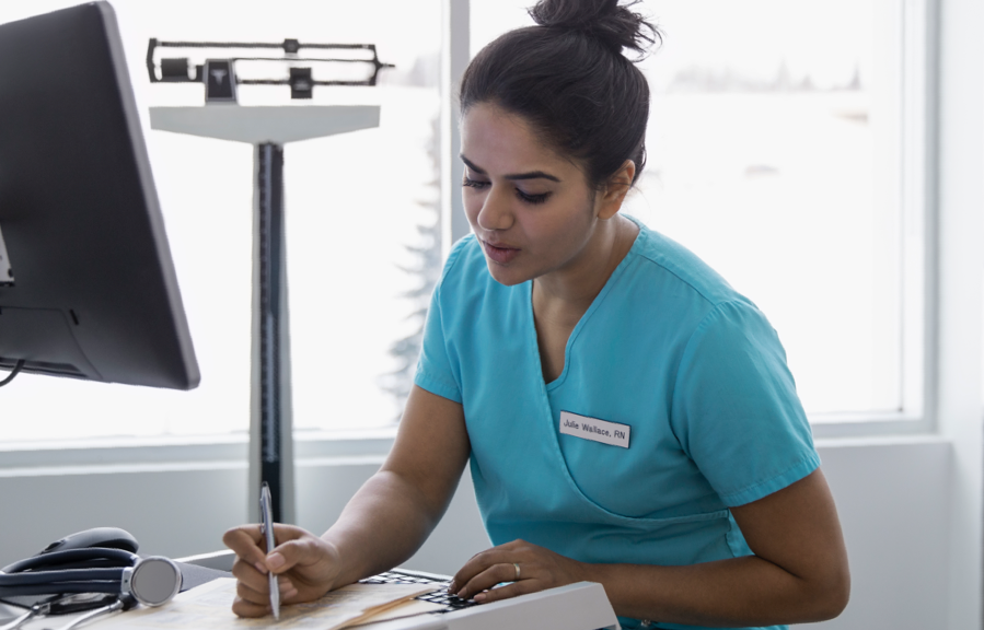 Female nurse writing on chart | BCBS of Tennessee
