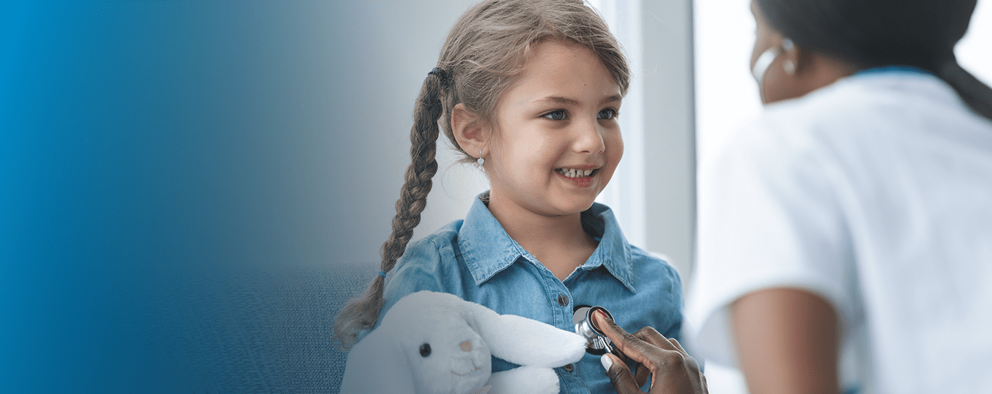 Little girl hold stuffed toy receiving checkup from provider