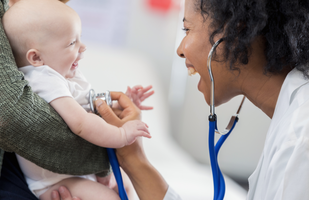 Doctor in white coat laughing with baby | BCBS of Tennessee
